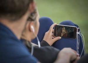 Ragazza che guarda un film con lo smartphone.